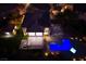 Aerial view of a gorgeous home featuring a pool with integrated hot tub, covered patio, and a well-manicured lawn at dusk at 2900 Valvent Ct, Henderson, NV 89044