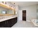 Bright bathroom boasts a double vanity with a stylish wood-trimmed mirror and a separate soaking tub with a glass enclosure at 2900 Valvent Ct, Henderson, NV 89044