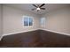 Spacious empty bedroom with hardwood flooring, ceiling fan, large windows with shutters, and neutral walls at 2900 Valvent Ct, Henderson, NV 89044