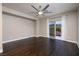An open bedroom has hardwood floors, a ceiling fan, and a sliding glass door to a balcony with mountain views at 2900 Valvent Ct, Henderson, NV 89044