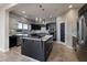 Modern kitchen boasts black cabinets, island with white countertop and sleek stainless steel appliances at 2900 Valvent Ct, Henderson, NV 89044