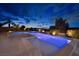 A long, luminous pool with an integrated hot tub, surrounded by desert landscaping and warm exterior lighting at 2900 Valvent Ct, Henderson, NV 89044