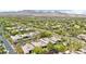 An elevated view captures the community with palm trees and desert landscaping with mountains in the distance at 304 Cambrian Ridge Ct, Las Vegas, NV 89144