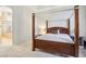 This main bedroom features a four-poster bed, neutral carpeting, and an ensuite bathroom with a soaking tub at 304 Cambrian Ridge Ct, Las Vegas, NV 89144