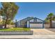 Charming two-story home featuring a two-car garage and manicured front lawn on a sunny day at 318 Heather Dr, Henderson, NV 89002