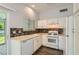 Bright eat-in kitchen features white cabinets, modern flooring, mosaic backsplash, and stainless steel sink at 318 Heather Dr, Henderson, NV 89002