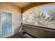 Cozy outdoor balcony featuring a textured wall, patterned glass door, and privacy screen with views of lush greenery at 3400 Cabana Dr # 1068, Las Vegas, NV 89122