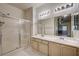 Bathroom with double vanity sink, white cabinets, and glass enclosed shower at 3400 Cabana Dr # 1068, Las Vegas, NV 89122