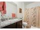 Well-lit bathroom featuring a single sink vanity, granite countertop, and shower-tub combo with floral curtain at 3543 E Malheur Ave, Pahrump, NV 89061