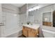 Bathroom featuring white tub and shower combo, wood vanity, and large mirror at 3930 Legend Hills St # 102, Las Vegas, NV 89129