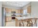 Bright kitchen featuring stainless steel appliances, light wood cabinets, and a breakfast bar with seating at 3930 Legend Hills St # 102, Las Vegas, NV 89129