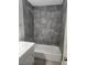 Updated bathroom with a modern tub-shower combo and gray tiled walls at 4300 N Lamont St # 249, Las Vegas, NV 89115