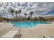 Community pool with surrounding palm trees, lounge chairs, and a blue sky at 4521 Bell Cord Ave # 103, North Las Vegas, NV 89031