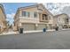 Street view of townhome exterior featuring a balcony, multi-car garages, and well-kept landscaping at 4521 Bell Cord Ave # 103, North Las Vegas, NV 89031