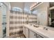 Well-lit main bathroom with double sinks, a large mirror, and a striped shower curtain at 4521 Bell Cord Ave # 103, North Las Vegas, NV 89031