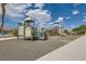 Community playground with multiple play structures on a rubber surface under a sunny sky at 4521 Bell Cord Ave # 103, North Las Vegas, NV 89031