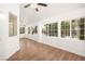 Sunroom with wood flooring, white walls, a ceiling fan, and many windows letting in lots of light at 4521 Crimson Leaf Dr, Las Vegas, NV 89130