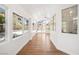 Long sunroom with many large windows, wood flooring, and white textured walls at 4521 Crimson Leaf Dr, Las Vegas, NV 89130