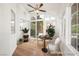 Bright sunroom with large windows, ceiling fan, and stylish seating area with table and plants at 4521 Crimson Leaf Dr, Las Vegas, NV 89130