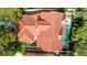 High-angle view of a red tile roof, set among mature trees and manicured landscaping, and a private pool at 5112 Onion Creek Ln, Las Vegas, NV 89113