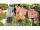An aerial view displays a well-maintained home with a red tile roof, mature trees and lush landscaping at 5112 Onion Creek Ln, Las Vegas, NV 89113