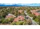 Scenic aerial view of a home with a terracotta roof surrounded by lush trees in a neighborhood, featuring mountains in the background at 5112 Onion Creek Ln, Las Vegas, NV 89113