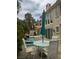 Inviting backyard with a pool, patio table with umbrella and mature trees surrounding the home at 5112 Onion Creek Ln, Las Vegas, NV 89113