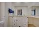 Bright bathroom featuring a large mirror, granite counters, and white cabinetry at 5112 Onion Creek Ln, Las Vegas, NV 89113