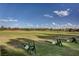 Expansive golf driving range on a sunny day featuring manicured greens, clear blue skies, and ample practice space at 5112 Onion Creek Ln, Las Vegas, NV 89113