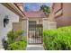 Charming private walkway leading to home through wrought iron gate and mature landscaping at 5112 Onion Creek Ln, Las Vegas, NV 89113