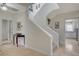 Entryway with staircase leads to an updated kitchen with white cabinetry and granite countertops at 5112 Onion Creek Ln, Las Vegas, NV 89113