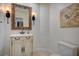 Charming powder room with decorative mirror, sconces, custom vanity, and neutral tile flooring at 5112 Onion Creek Ln, Las Vegas, NV 89113