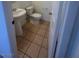 Cozy powder room featuring pedestal sink, tile floors, and a toilet at 523 Cabis Bay St, Las Vegas, NV 89178