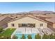An aerial view of a backyard featuring a pool and spa, a patio, artificial grass, and mountain views in the distance at 5321 Brayden Ct, Las Vegas, NV 89131