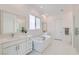 Modern bathroom with double vanities, a soaking tub, and a glass-enclosed shower at 5321 Brayden Ct, Las Vegas, NV 89131