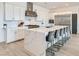 Modern kitchen with white cabinets, stainless steel appliances, and a large marble island with seating at 5321 Brayden Ct, Las Vegas, NV 89131