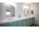 Bathroom featuring double sinks, custom vanity, decorative mirrors and bright natural light at 54 Blue Fountain Ct, Henderson, NV 89012
