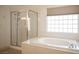 Bathroom featuring walk-in shower, soaking tub, and window with blinds for privacy at 54 Blue Fountain Ct, Henderson, NV 89012