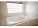 Close up of the bathtub, window and blind, adding privacy to the bathroom at 54 Blue Fountain Ct, Henderson, NV 89012