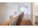 Bright upstairs hallway featuring carpeted floors, wood railing and leads to a bathroom at 54 Blue Fountain Ct, Henderson, NV 89012
