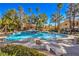 Community pool area featuring a rock waterfall, seating, and lush greenery for a relaxing atmosphere at 541 Indian Bluff St # 201, Las Vegas, NV 89145