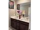 Bathroom featuring double sinks, granite countertops, and dark wood cabinetry at 5550 Jinan St, Las Vegas, NV 89148
