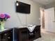 Living room boasts a mounted TV, a dark wood TV console, and neutral carpet at 5550 Jinan St, Las Vegas, NV 89148