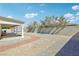 Large backyard with gravel landscaping, a covered patio, and a block wall offering privacy at 564 Lampshire Ln, Pahrump, NV 89060