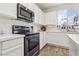 Modern kitchen featuring black stainless steel appliances, white cabinets and countertops and an open window at 564 Lampshire Ln, Pahrump, NV 89060