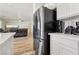 Modern kitchen with stainless steel refrigerator and white cabinetry adjacent to a casual living space at 564 Lampshire Ln, Pahrump, NV 89060