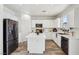 Bright kitchen featuring white cabinets, stainless steel appliances, a center island, and stylish flooring at 564 Lampshire Ln, Pahrump, NV 89060