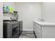 Efficient laundry room with modern washer and dryer set and a sink with a quartz countertop at 564 Lampshire Ln, Pahrump, NV 89060