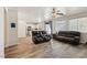 Open concept living room with a view into the kitchen, wood floors, and plenty of natural light at 564 Lampshire Ln, Pahrump, NV 89060