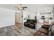 Spacious living area with wood floors, a ceiling fan, and an open layout leading to the kitchen at 564 Lampshire Ln, Pahrump, NV 89060